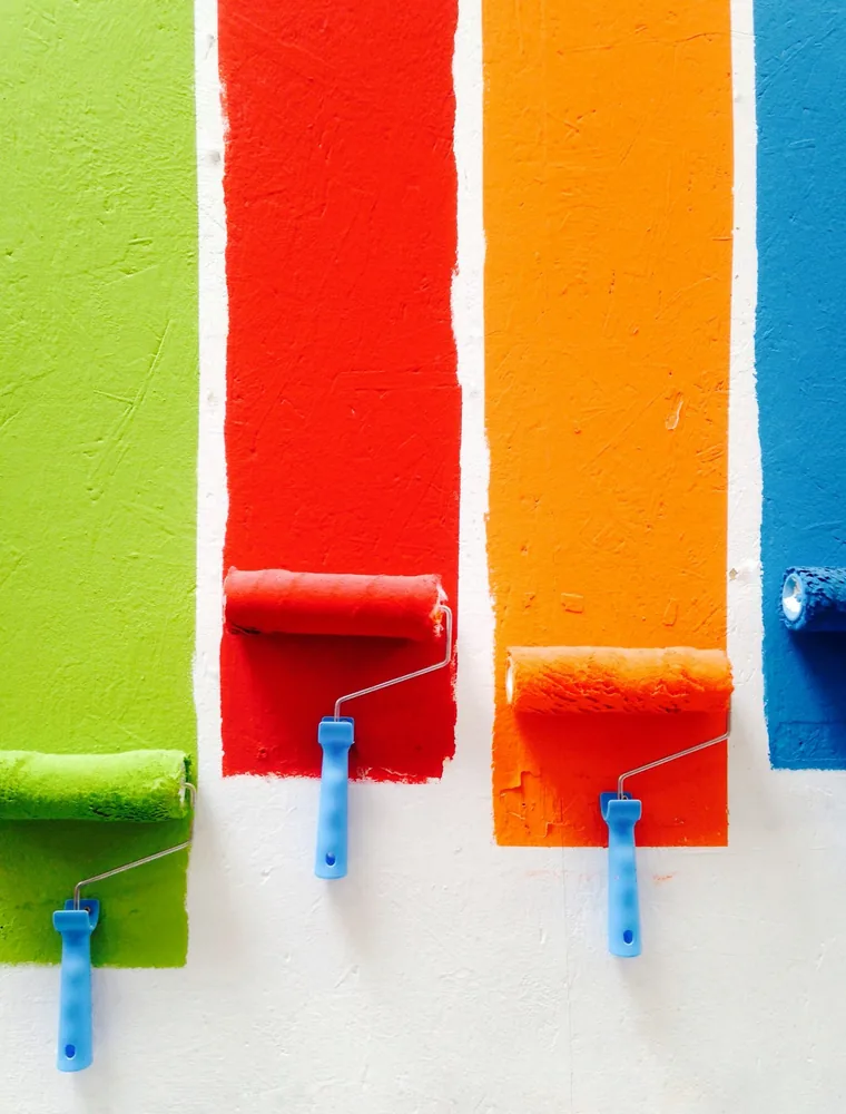 Paint rollers striped in green, red, orange and blue